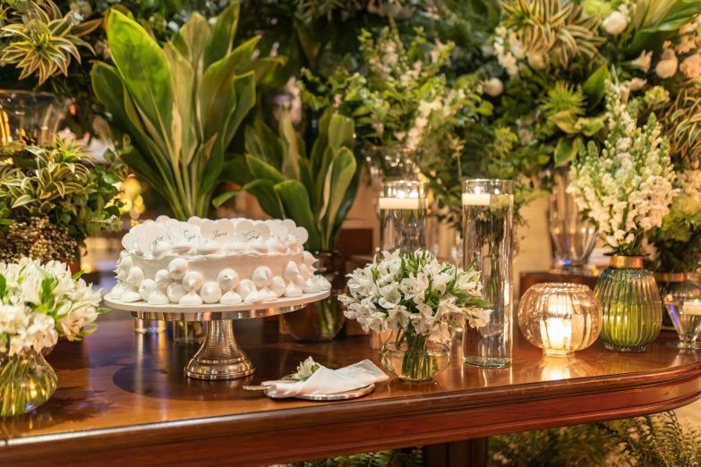 an assortment of glass vases, candles and flowers on a table