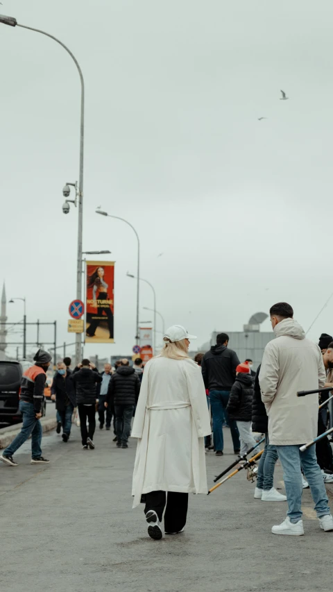 some people are standing and a guy is holding a skateboard