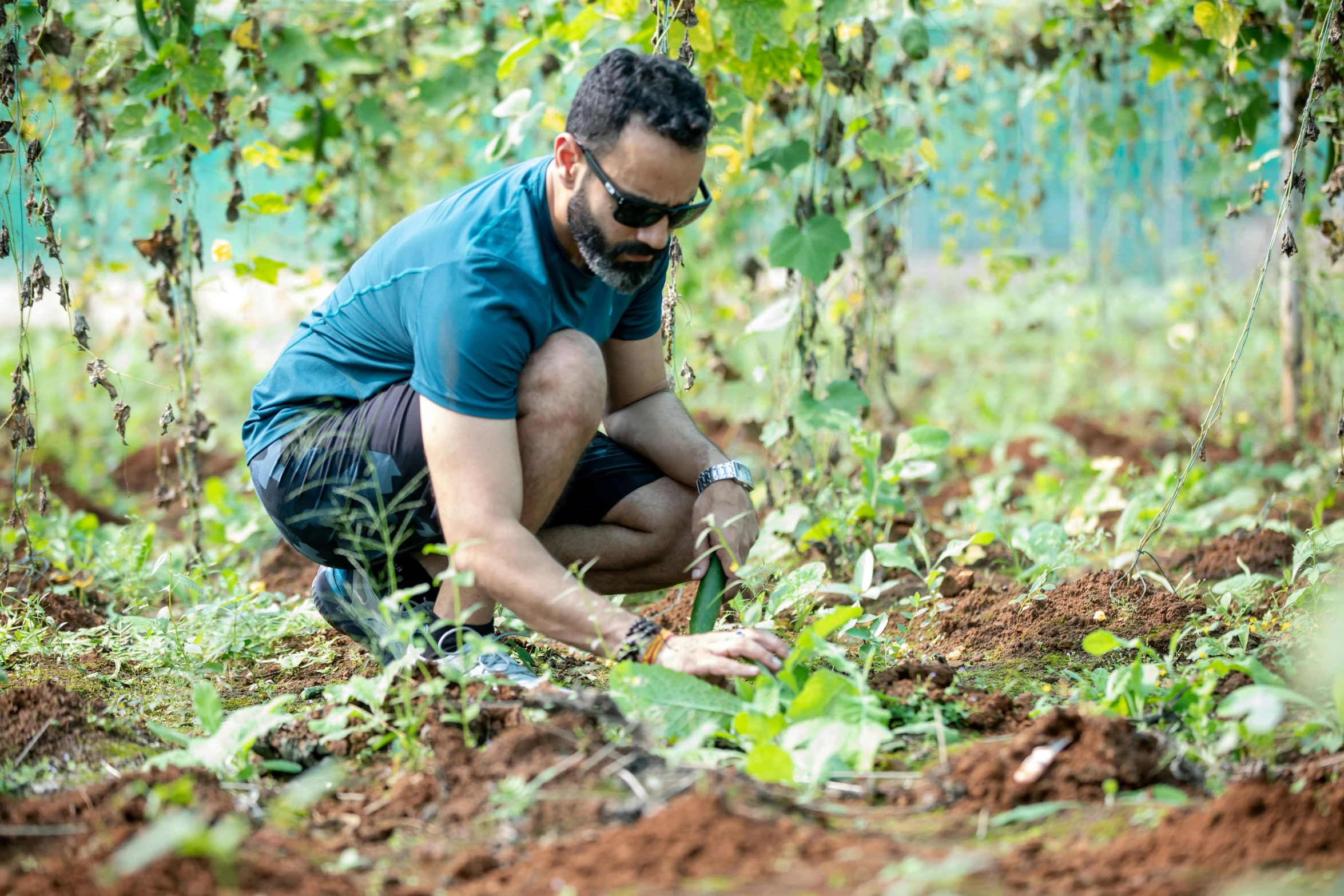 a man wearing sunglasses crouching in the ground