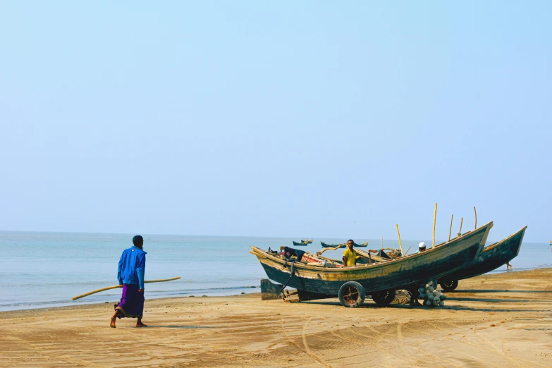 a person standing by a boat on the shore