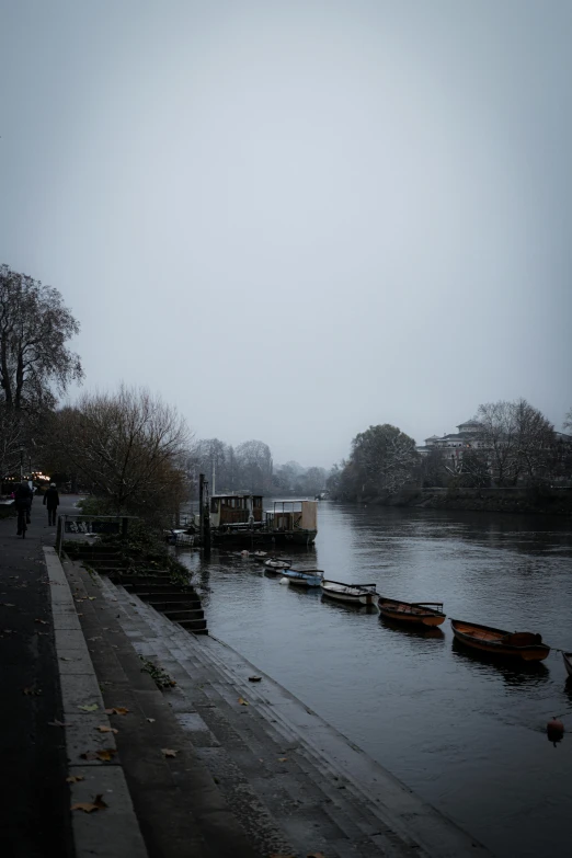 a waterway on a foggy day has boats and people