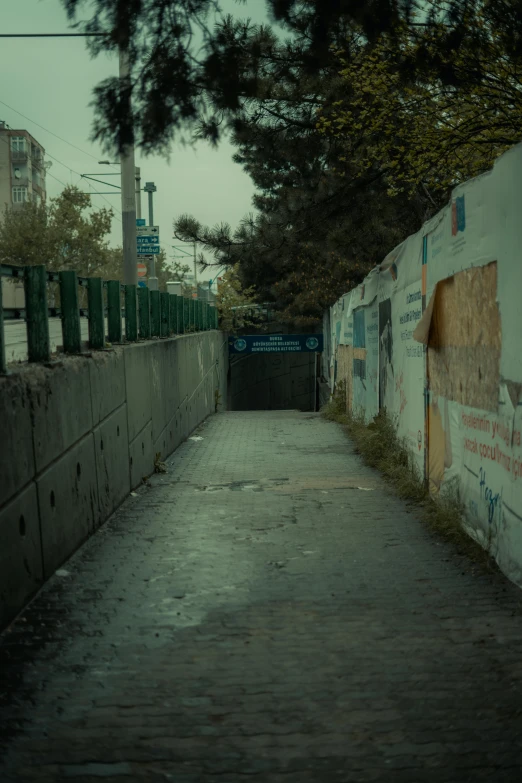 an empty city street with graffiti on the wall and buildings