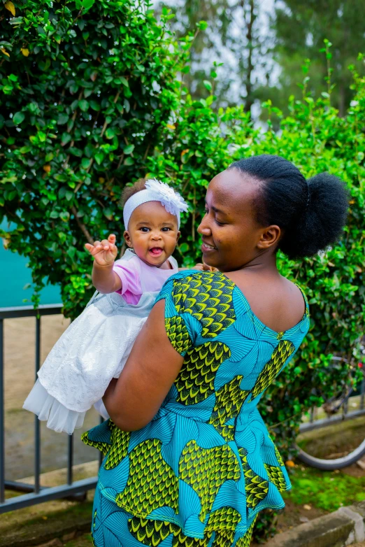 an african woman holding a baby while staring away