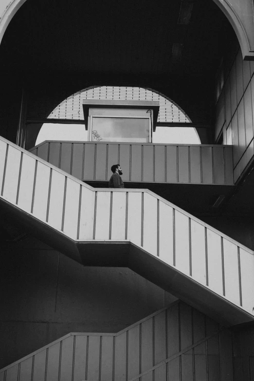 a man walking down some stairs under an arched archway