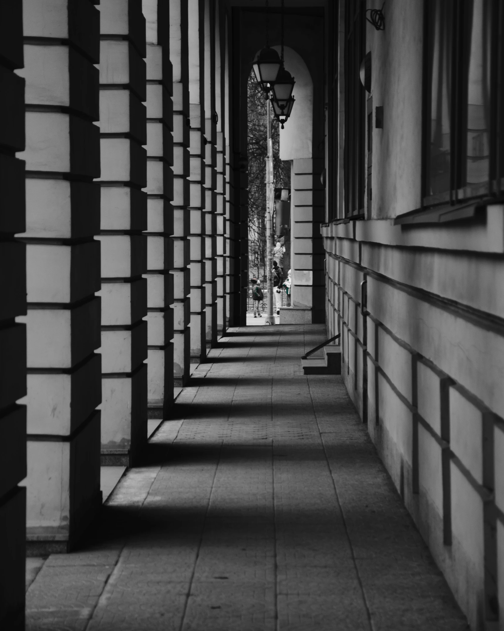 an empty long sidewalk with a black and white image of buildings