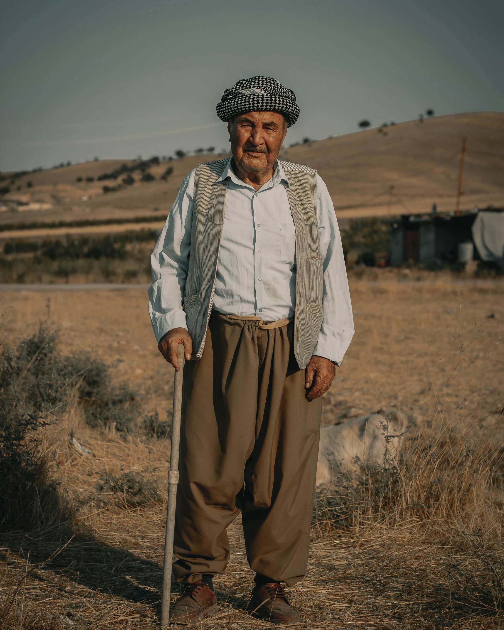 an old man wearing a long stick in the field
