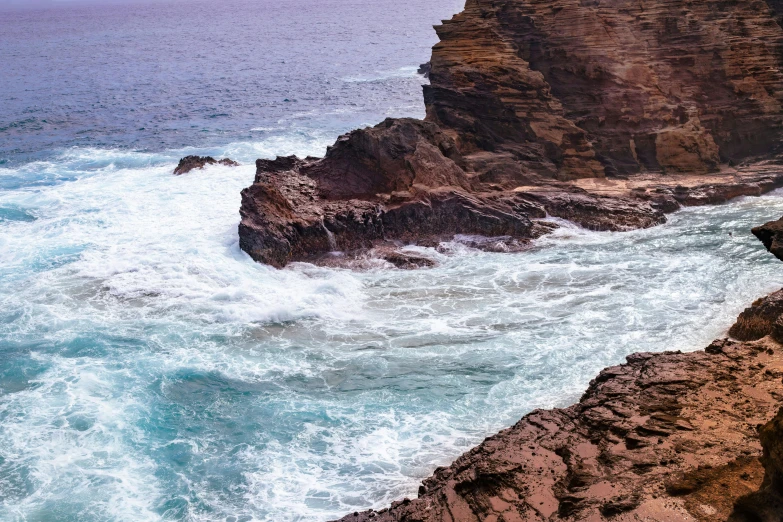 a rocky coastline with white foamy waves crashing onto the shore