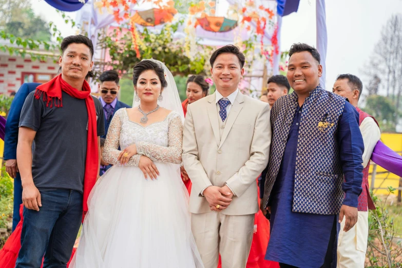 wedding party posing for a pograph with asian bride