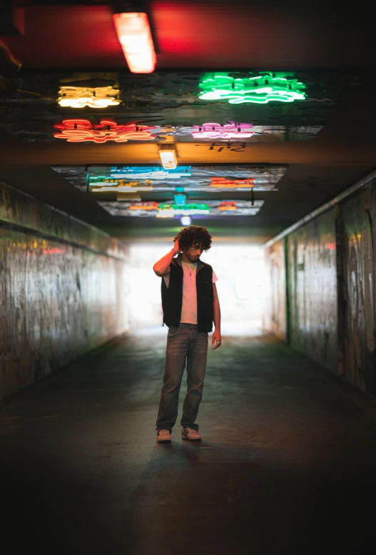 a man standing in a dark tunnel wearing a vest