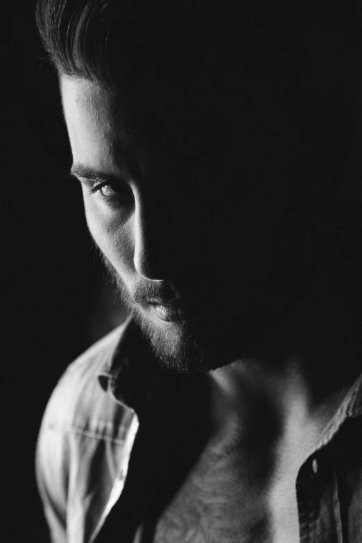 man with shirt on staring at soing in black and white