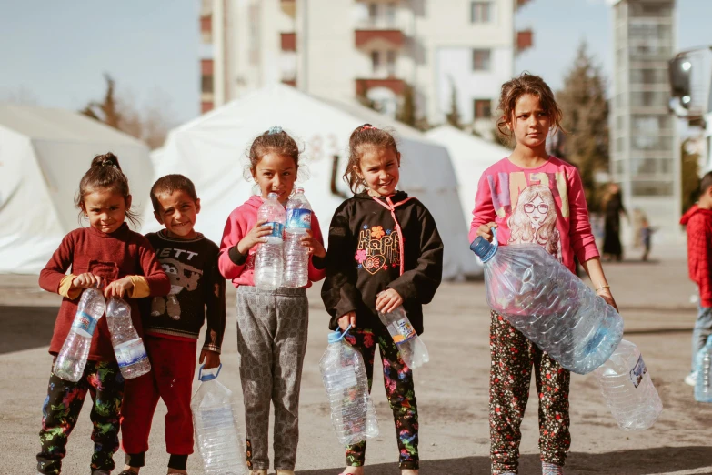 three little girls with plastic bags in hand