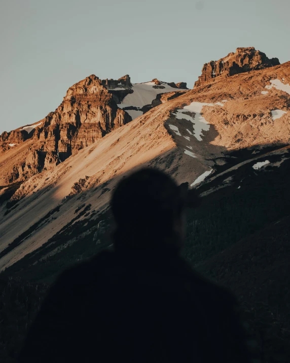 a person in the silhouette with some mountains behind them