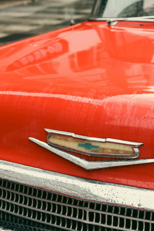 closeup of a old, bright red car in the rain