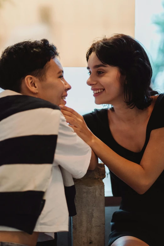 a woman is sitting next to a man and laughing