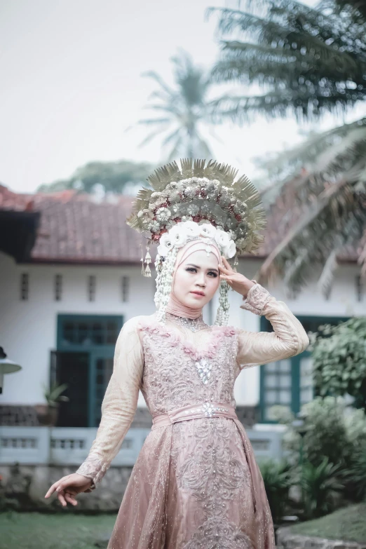 a woman wearing a pink dress and head piece