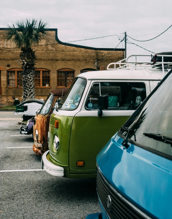 two people with backpacks stand near the tail end of a green and white van