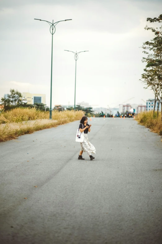 a person taking a picture while skateboarding down a road