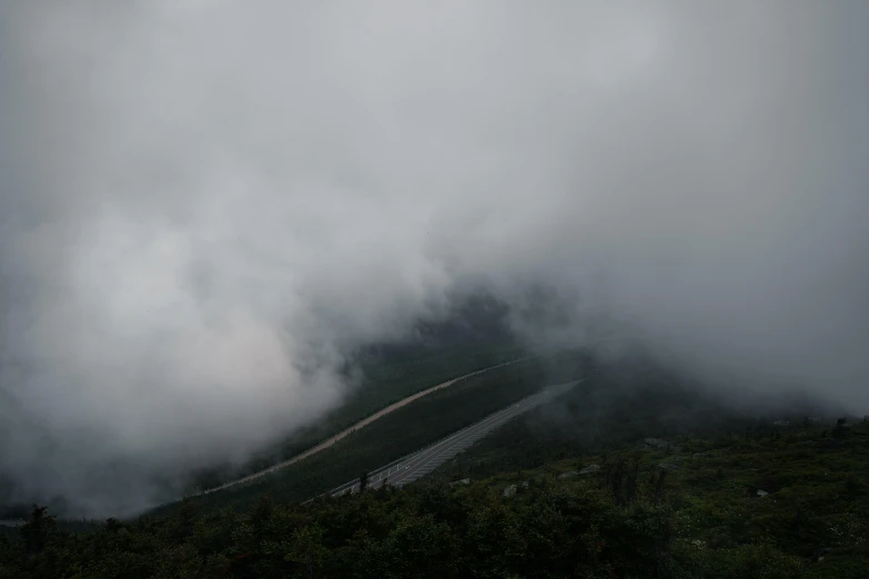 the landscape on the mountain is covered in clouds and snow