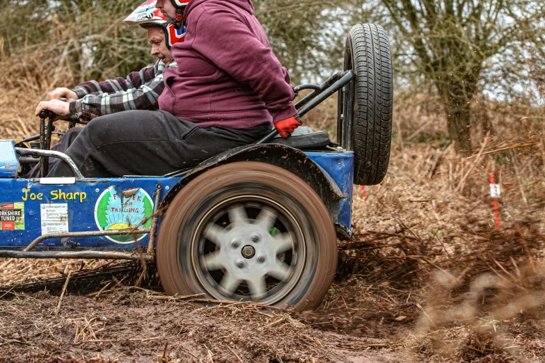 two men riding a mini dune buggy in the woods