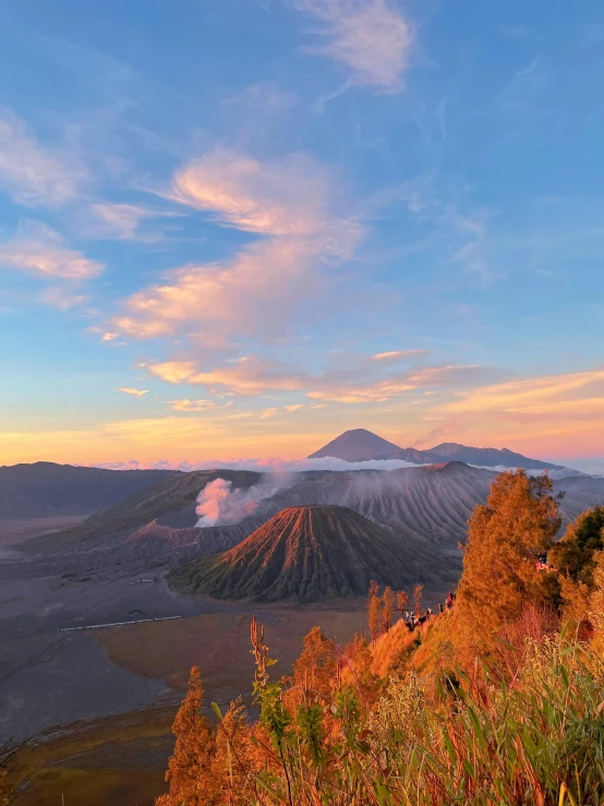 a hill is covered in smoke, and there are many things on the top