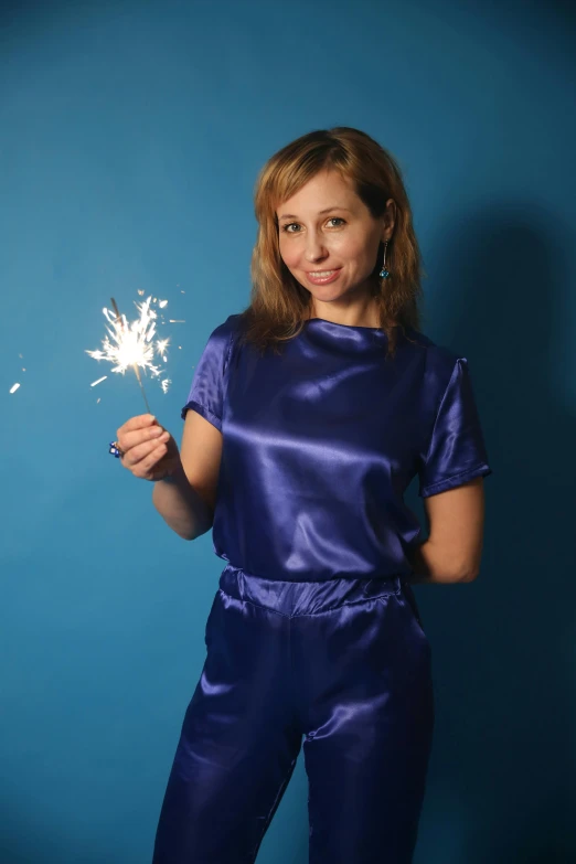 young woman holding firework in hand posing for the camera