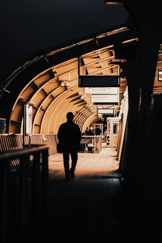 a man is walking down an empty subway station