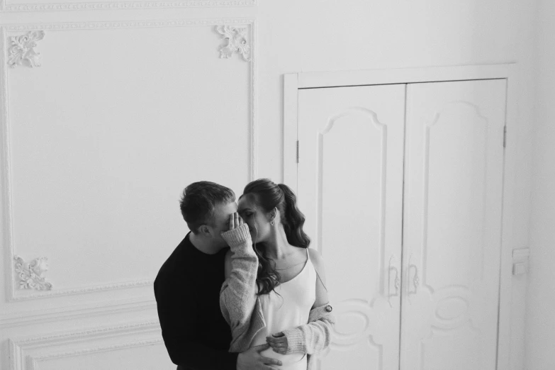 man and woman stand in front of a white painted door