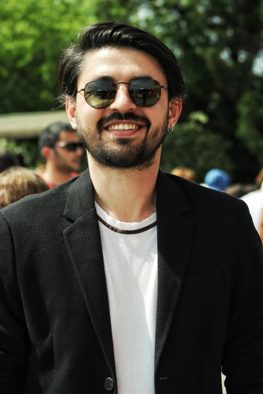 an attractive man with sunglasses smiling for the camera