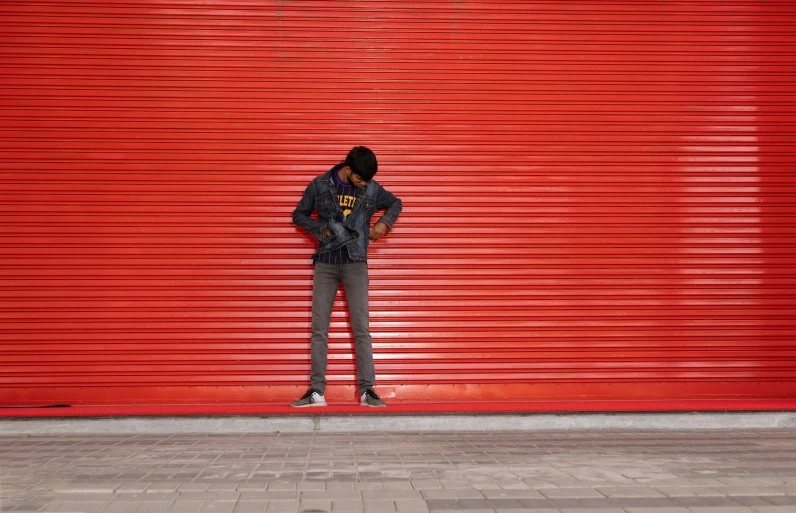 a man standing in front of a red garage door