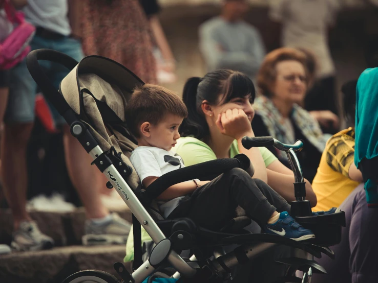 people are watching a man driving a baby stroller