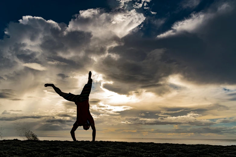 a person stands in the sun with their arms outstretched