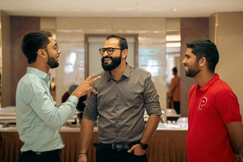 three men laugh together at a business meeting