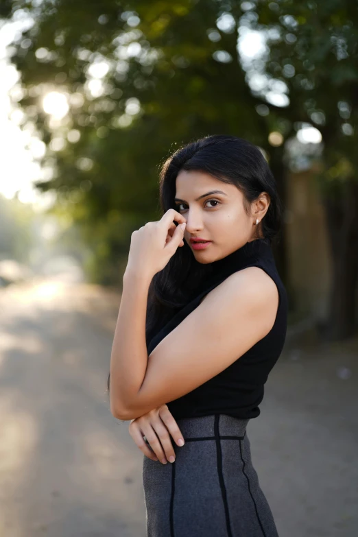 a young woman standing with her hands near her face