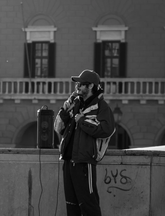 a man in a winter coat is standing in front of a wall