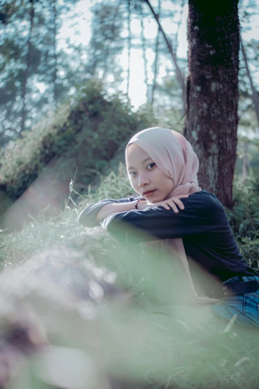 a young woman wearing a headscarf in a grassy area