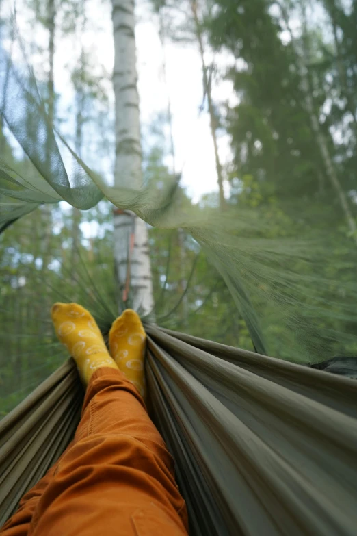 a hammock and feet resting in the middle of it