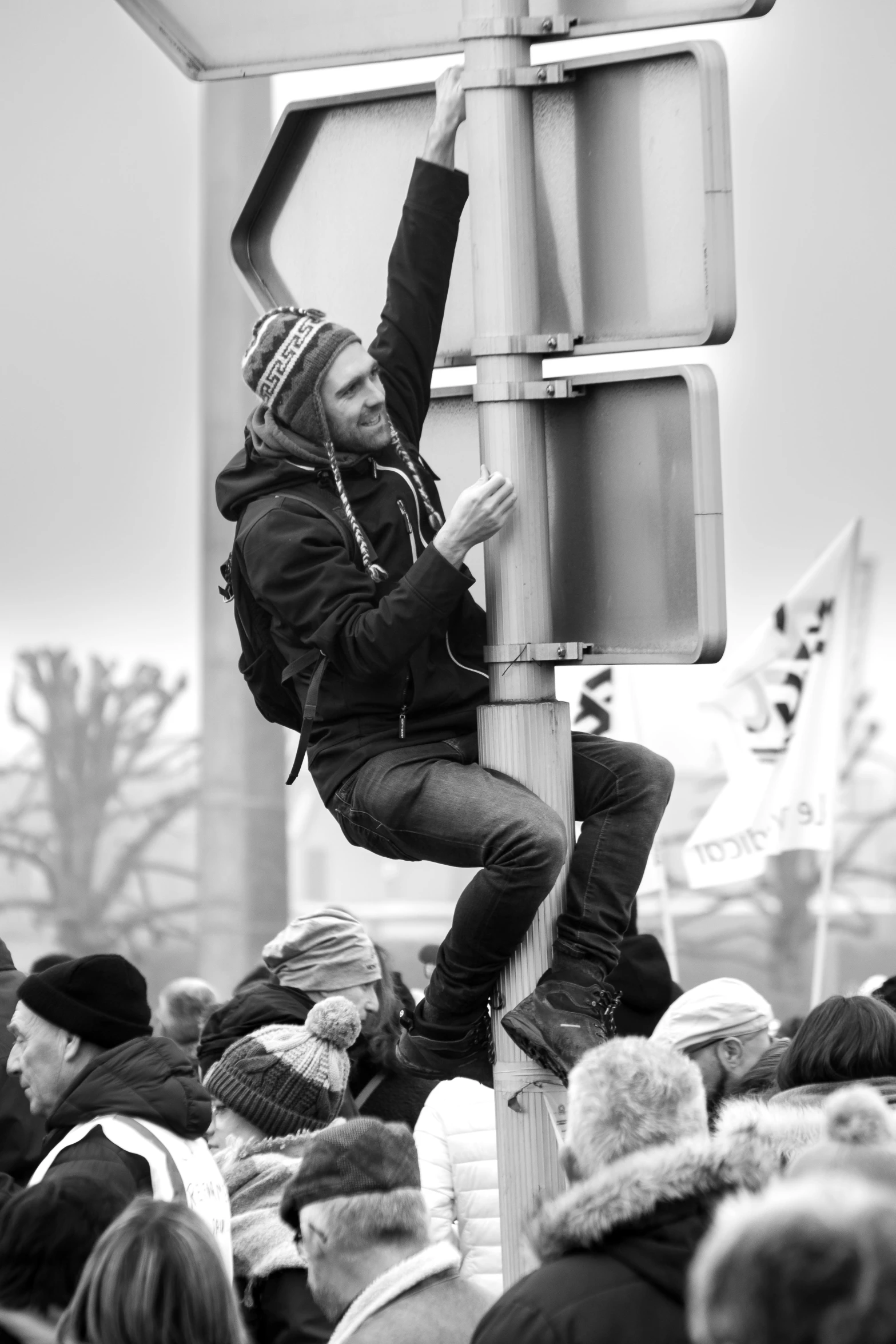 there is a man climbing the sign to get on the street