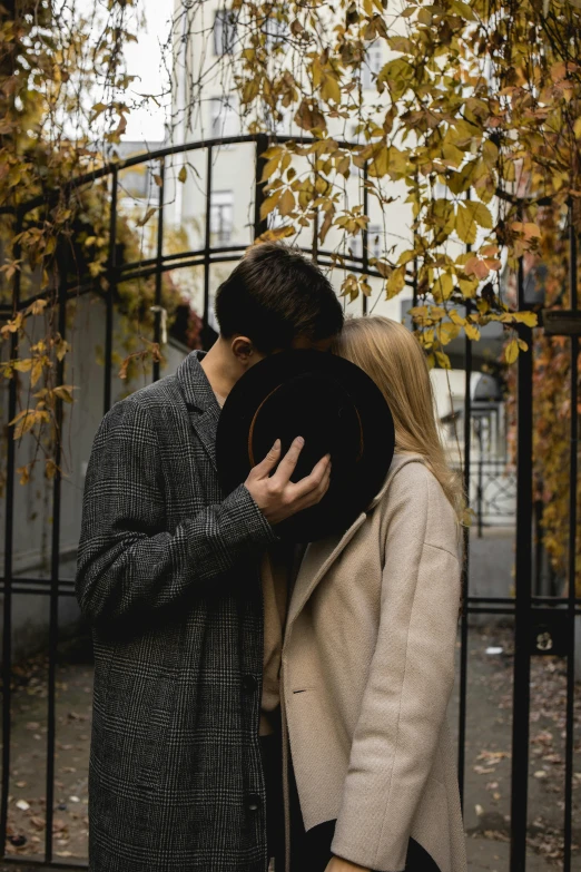 a couple standing in front of an iron gate