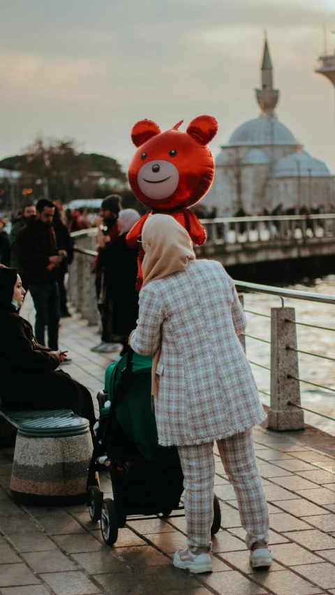 a red teddy bear sitting on top of a man