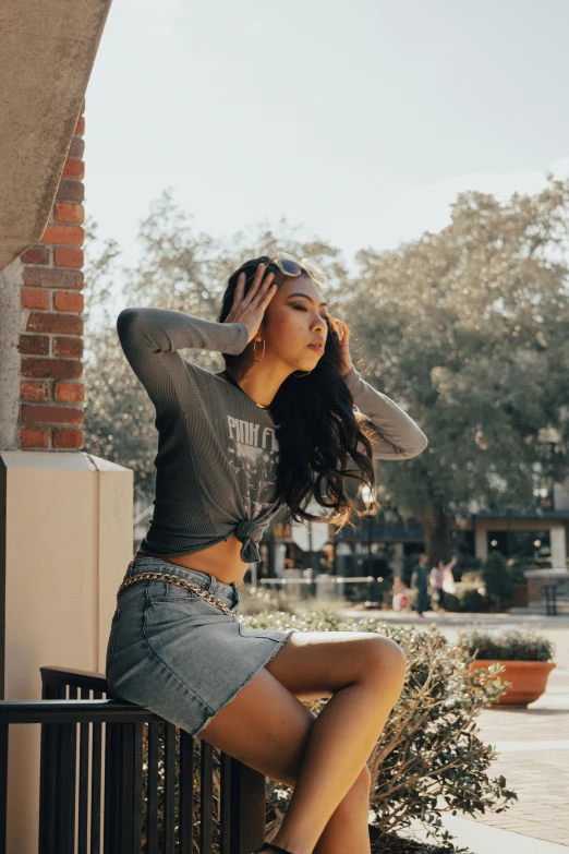 a young woman is sitting down on a railing