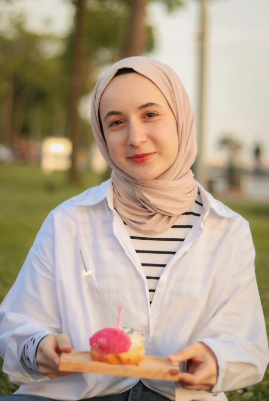 a woman holding an item with some food on it