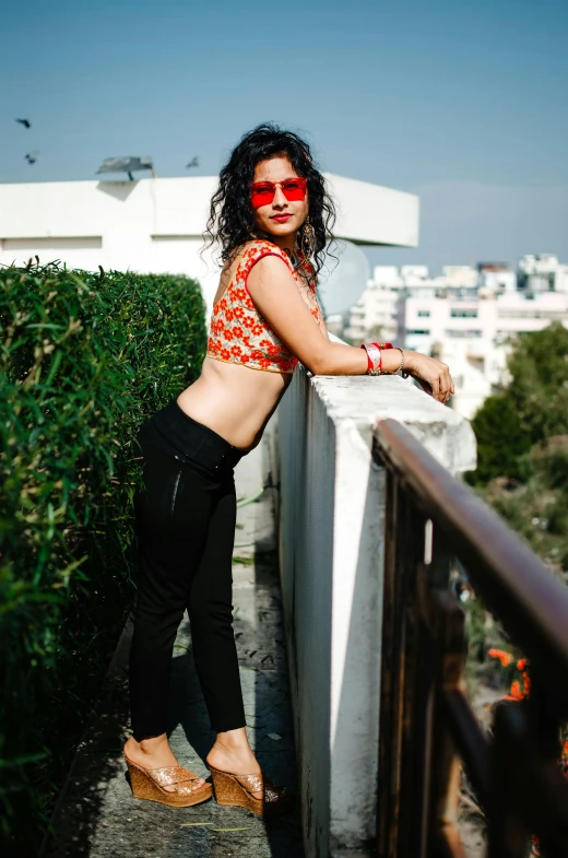 a woman is leaning against the edge of a balcony