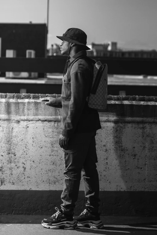 a man in hat and jacket holding onto his backpack