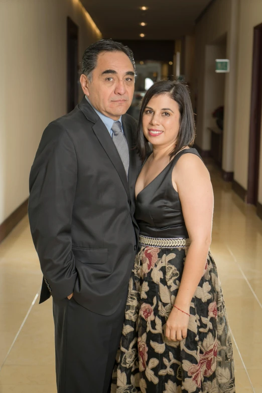 a man and woman standing together in an elegant dress