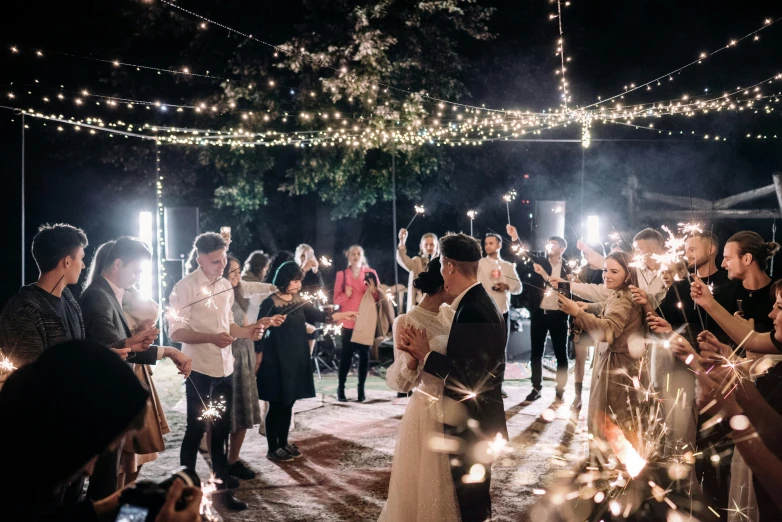 bride and groom walking down the aisle carrying sparklers at their wedding