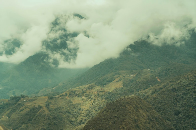 the clouds hovers above the hills in the mountains