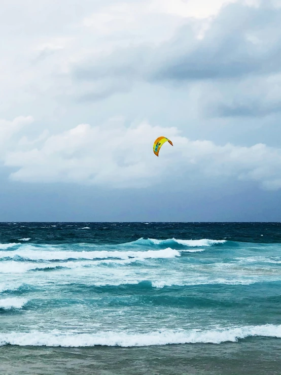 a parasailer over an ocean on the waves