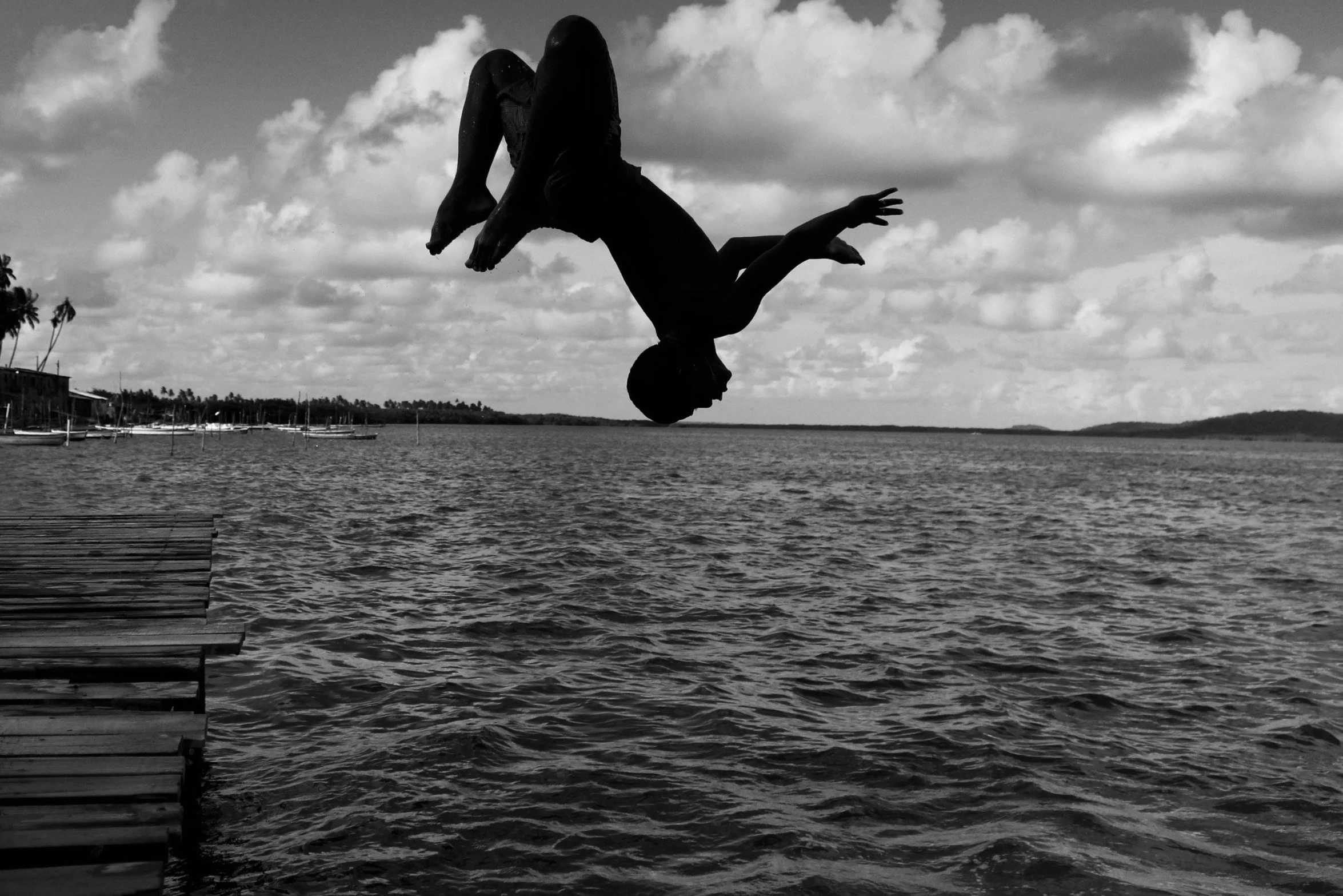 a woman in black shirt diving into the water