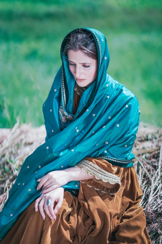 an old po of a young woman wearing a green veil