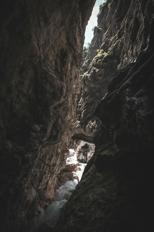 a dark, rocky mountain with little water flowing in the cave